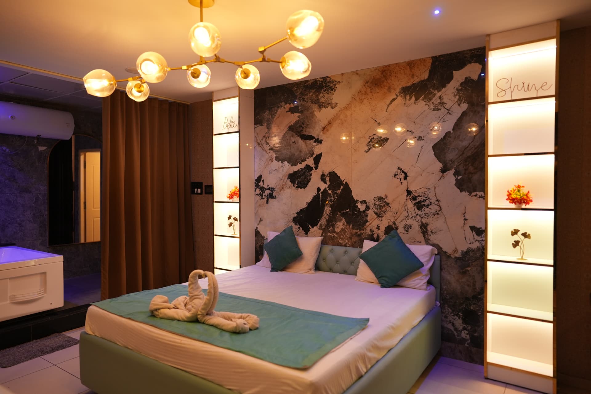 Luxury spa suite with marble wall, chandelier and jacuzzi view